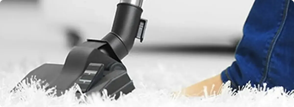 Close-up of a professional vacuuming a white carpet in Duncanville.